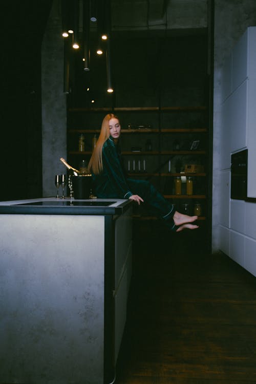 Free Woman in Green Pajama Sitting on a Table Stock Photo