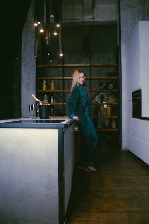 Free A Woman in Her Pajamas Leaning on a Kitchen Island Stock Photo