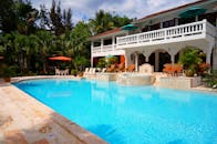 这座豪华别墅拥有令人惊叹的户外场景，包括晶莹剔透的游泳池和郁郁葱葱的热带花园