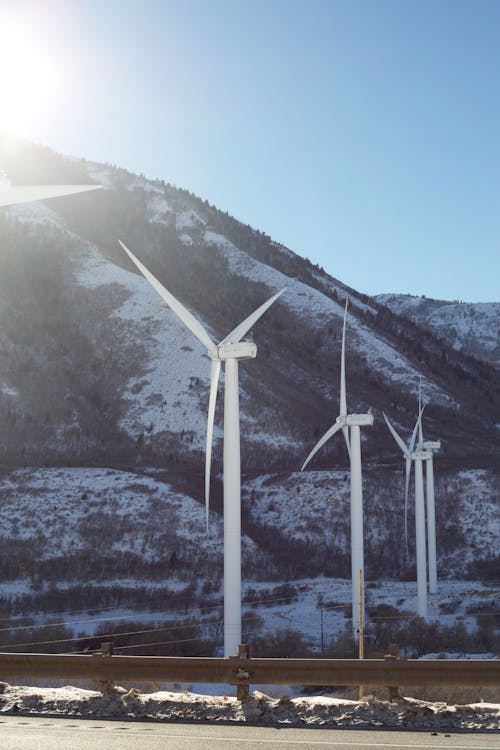 Wind Turbines near Snow-Covered Mountain