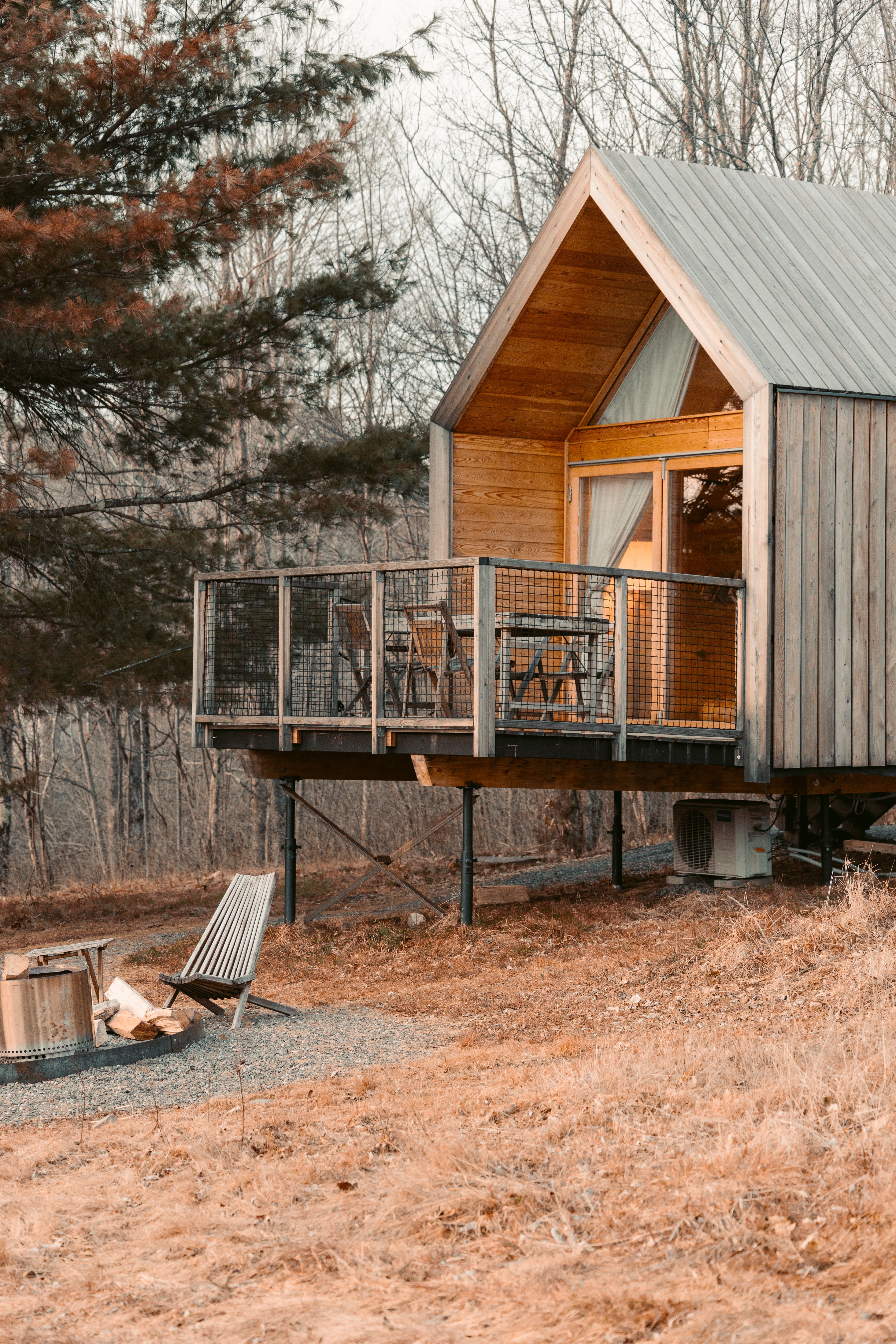 Free Cozy wooden cabin nestled in serene rural landscape with autumn vibes. Stock Photo