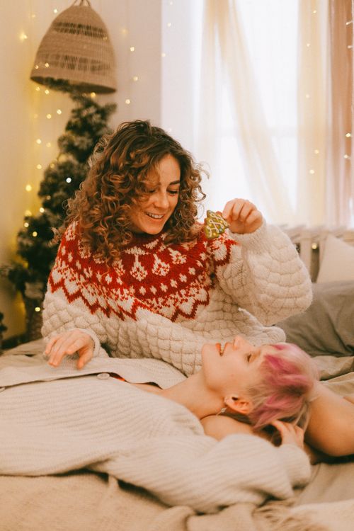 Free Warm holiday scene of a couple sharing affection in a festive setting indoors. Stock Photo