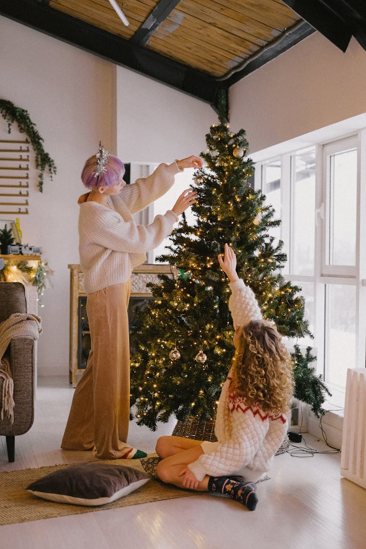 A Couple Decorating A Christmas Tree