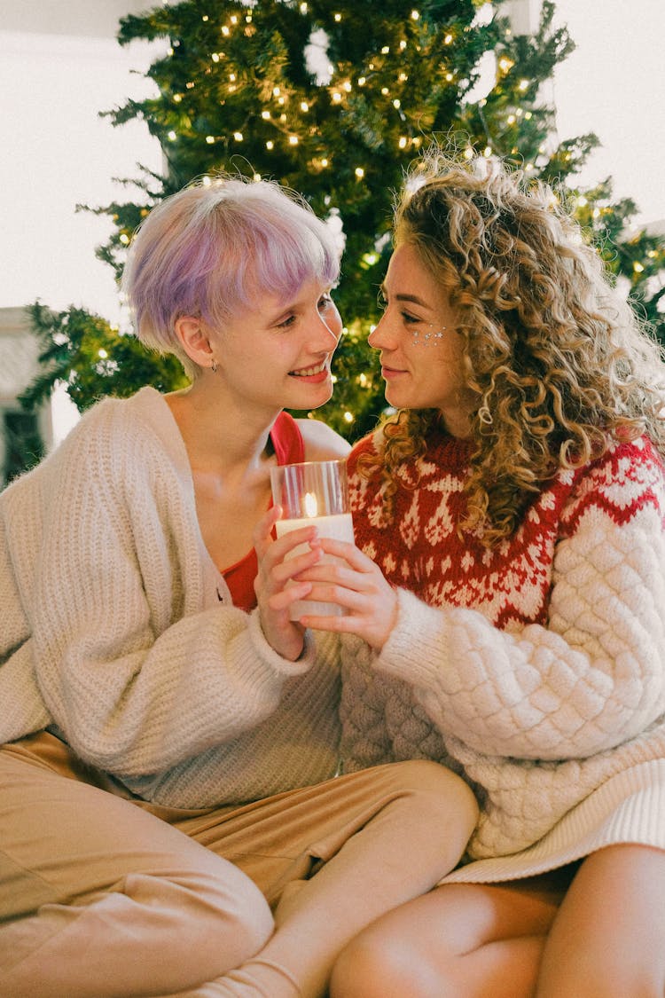 A Couple Holding A Candle While Looking At Each Other