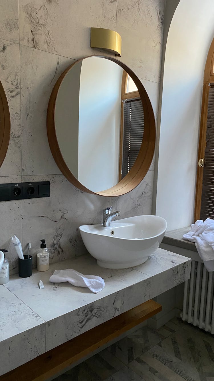 Bathroom Interior With Sink And Round Mirror