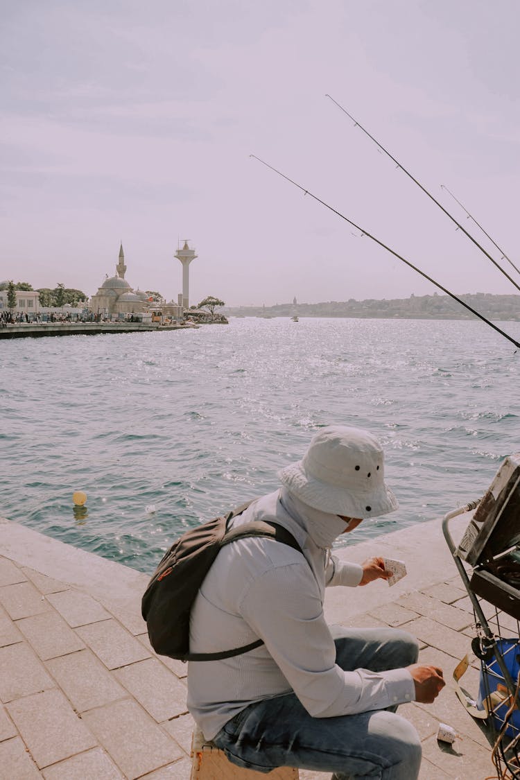 Man Fishing In City Bay