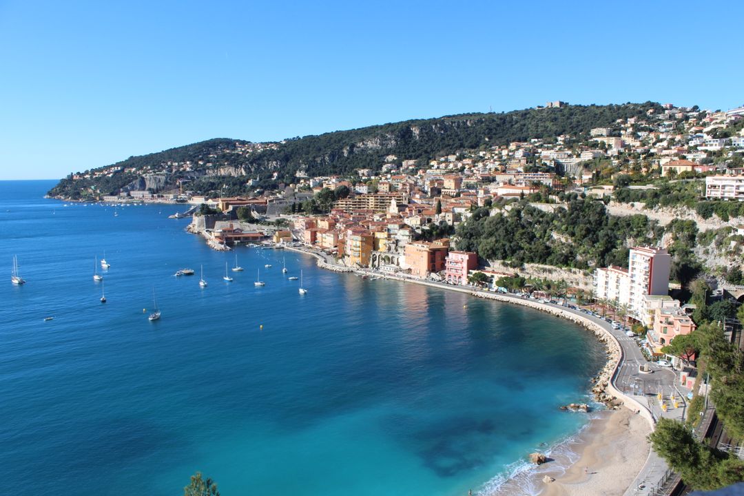 La baie à Villefranche-sur-Mer, avec la vieille ville ocre et la citadelle au-dessus d'une eau turquoise