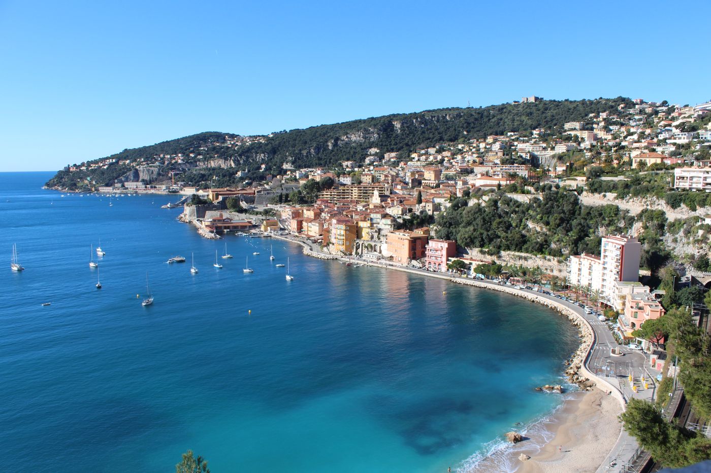 Aerial view of Villefranche-sur-Mer, its hillside houses and boats in the bay