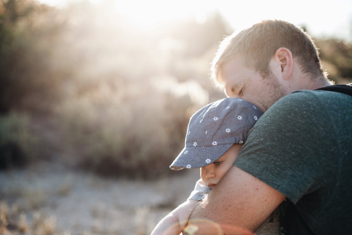 Free A Man Hugging his Baby on a Sunny Afternoon  Stock Photo