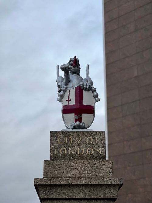 Free Stone monument featuring a dragon crest and City of London inscription in daylight. Stock Photo