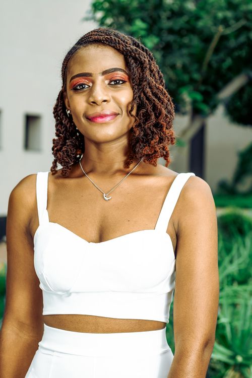 Free Stunning portrait of a woman in white attire, captured outdoors with a vibrant backdrop. Stock Photo