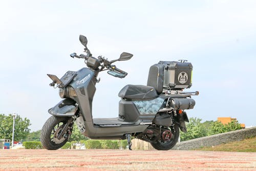 A Black Motor Scooter Parked on the Road