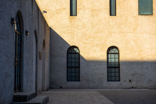 Free A minimalist facade with arched windows and shadows in Beijing, China. Captures modern architectural simplicity. Stock Photo