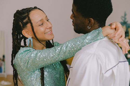 Free A happy interracial couple embracing with smiles in a warm indoor setting, showcasing love and togetherness. Stock Photo