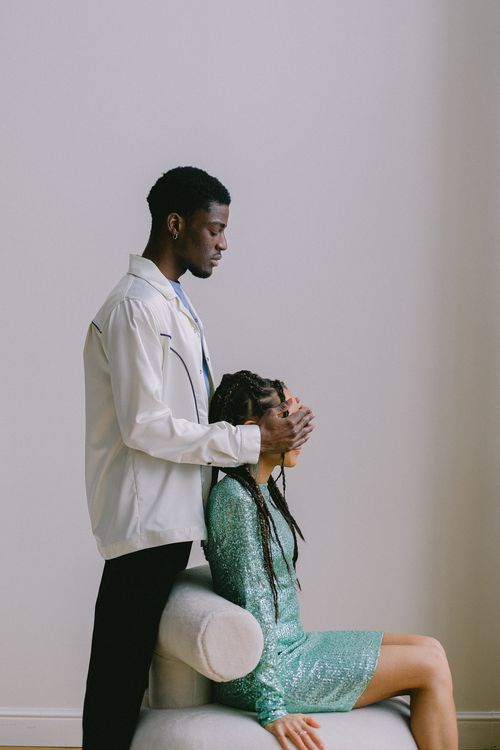 Free A young man gently covers his partner's eyes in an intimate indoor setting. Stock Photo