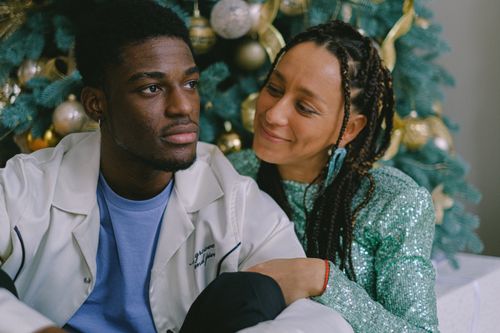 Free A loving couple enjoys holiday time by the decorated Christmas tree indoors. Stock Photo