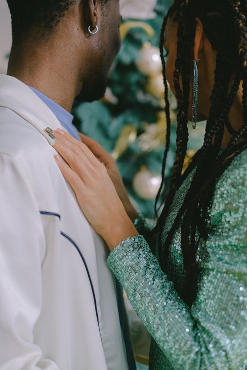 Free A couple sharing an intimate moment near a decorated Christmas tree. Stock Photo