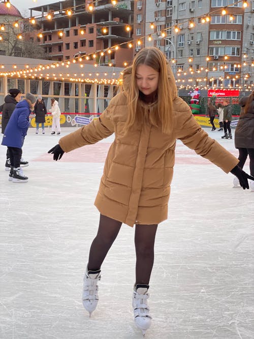A Woman in Winter Clothes Having Fun Ice Skating