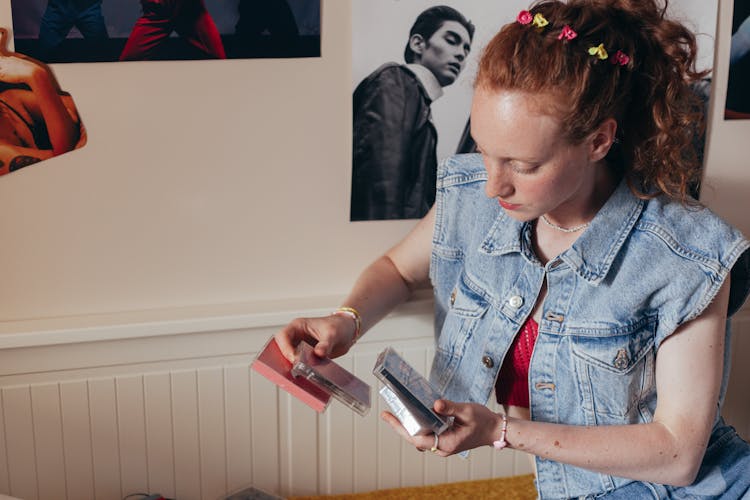 A Woman In Denim Vest Holding Cassette Tapes