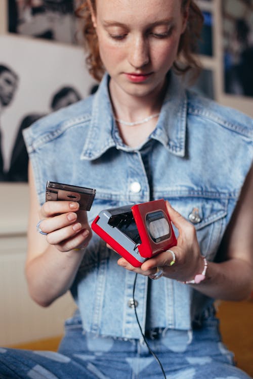 Woman in Blue Denim Button Up Jacket Holding a Cassette Player and Tape