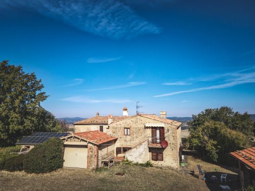 Free Beautiful rustic house with solar panels amidst nature under a clear blue sky. Perfect for sustainable living. Stock Photo