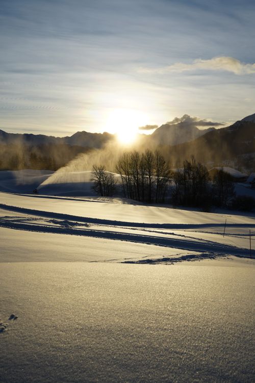 Free Beautiful winter sunrise over a snow-covered field in Crans-Montana, Switzerland. Stock Photo