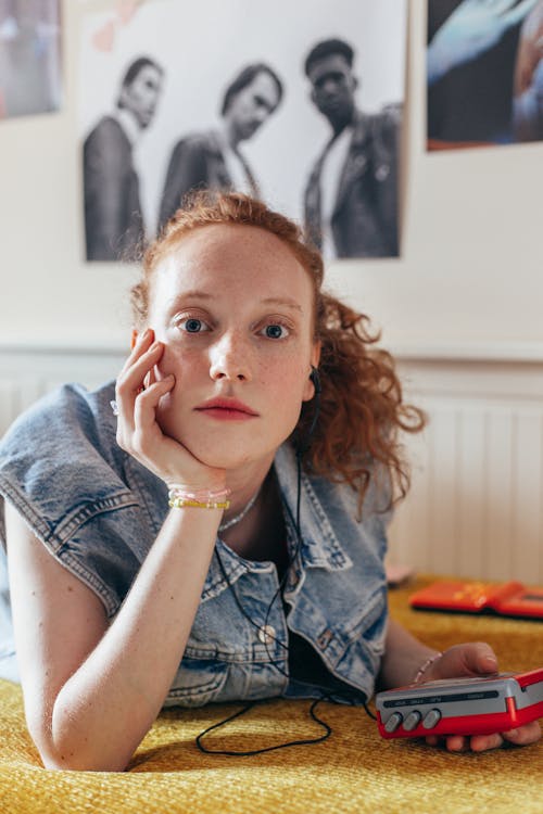 Woman in Blue Denim Vest Holding a Cassette Player 