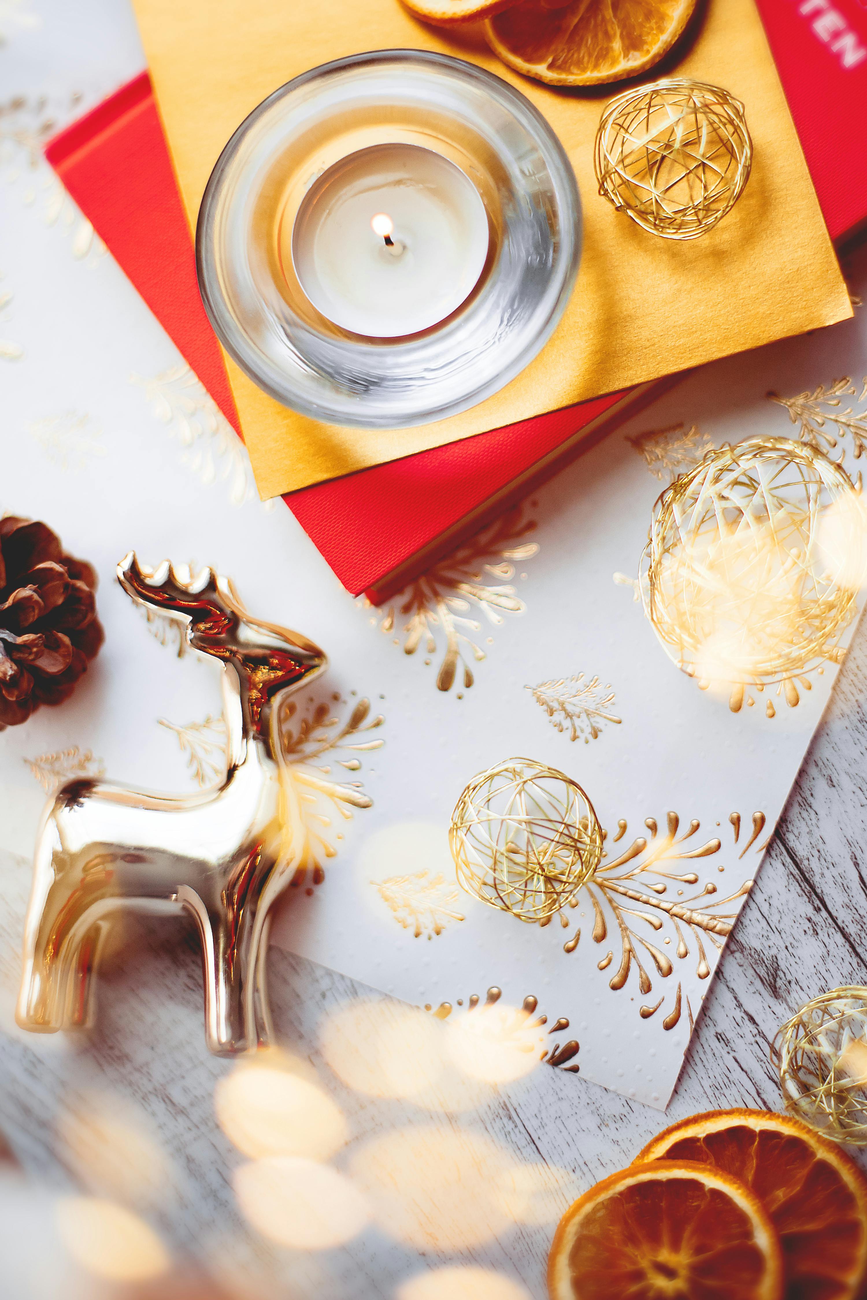 Gold reindeer and candle arrangement with Christmas decor on a wooden table.