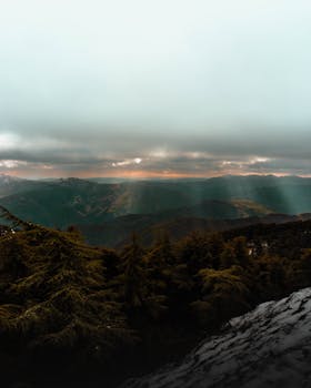 Breathtaking mountain view in Chrea National Park, Algeria, under a cloudy sky at sunset.