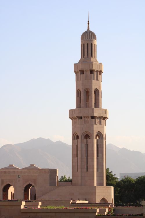 Free Elegant minaret of Sultan Qaboos Grand Mosque with a mountainous backdrop, Muscat, Oman. Stock Photo