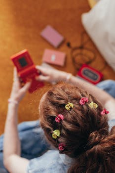 Woman using retro gamepad with colorful hair clips, evoking 90s nostalgia.