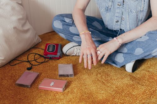 Free A person in denim with cassette tapes and a Walkman, evoking 90s nostalgia. Stock Photo
