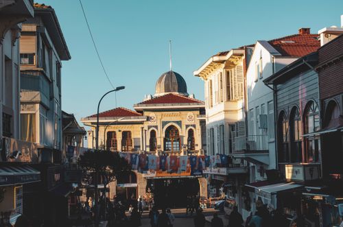 Free Sunlit urban scene featuring historic buildings and vibrant community ambiance. Stock Photo