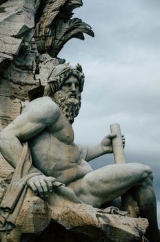 Dramatic view of a classical sculpture set against a moody sky.