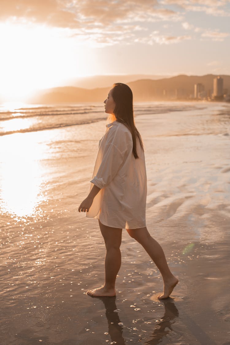 Woman In The White Shirt Walking On The Beach