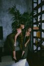 Blond Woman in Green Silk Dress Leaning Towards Mirror and Looking at Reflection