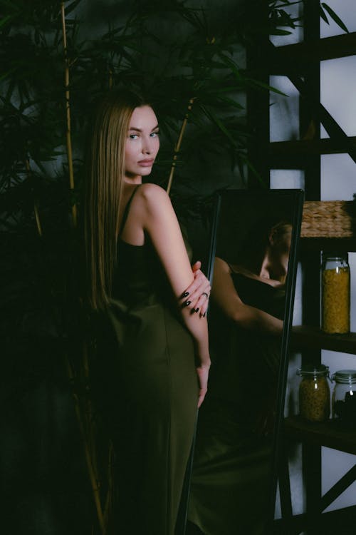Free Blond Young Woman in Silk Cocktail Dress Standing and Looking Over Her Shoulder Stock Photo