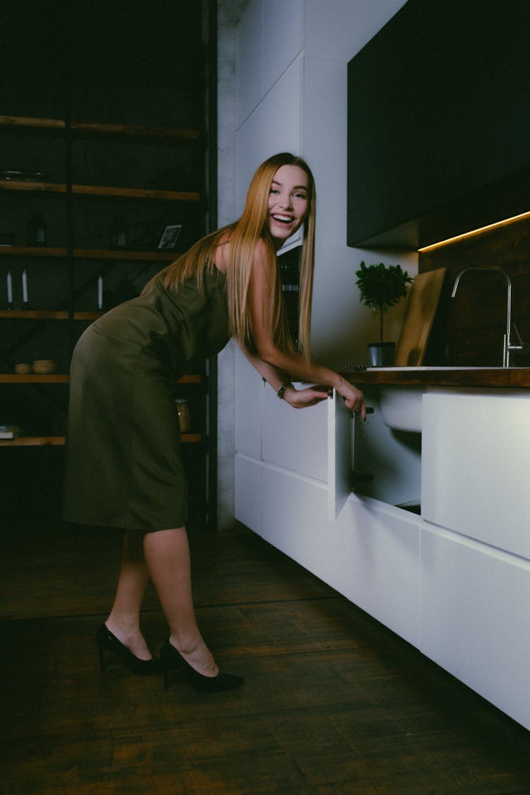 Woman Opening The Cupboard In The Kitchen