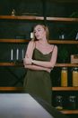 Woman Standing with Arms Crossed and Shelves behind her