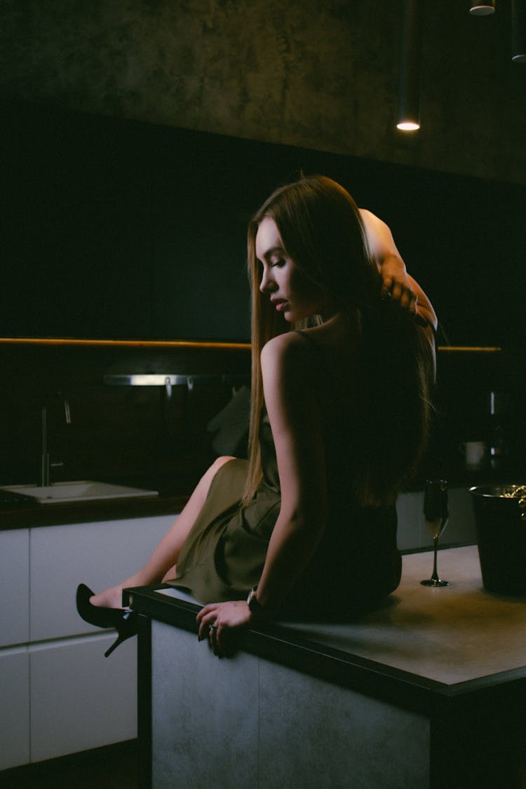 Woman Sitting On The Worktop In The Kitchen