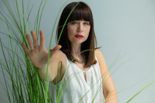 Woman in White Top Touching Grass