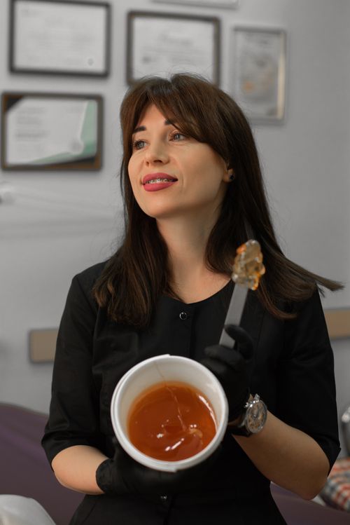 Free Brunette woman holds honey jar indoors, showcasing food therapy concept. Stock Photo