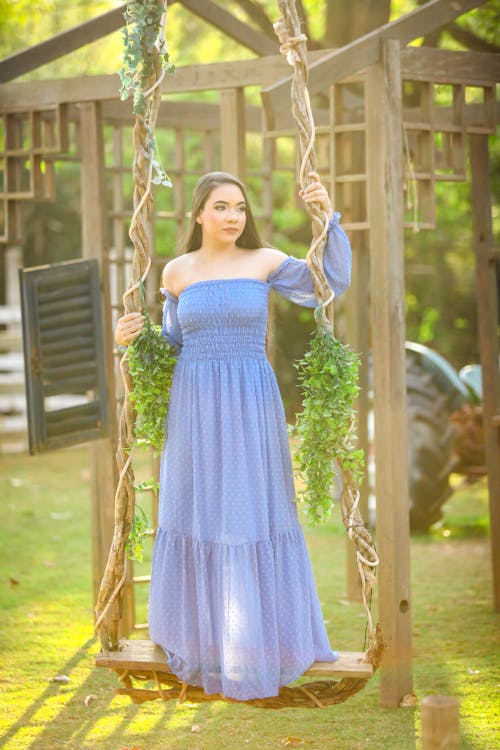 Woman in Blue Dress Standing on a Swing