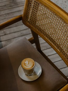Warm interior shot of a latte on a saucer and wooden chair in a Turkish cafe.