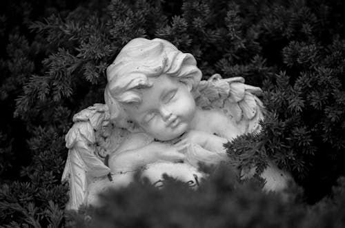 A White Angel Figurine in Grayscale Photography
