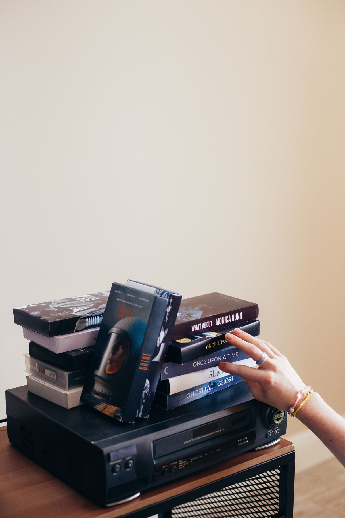 Stack of VHS tapes on a VCR