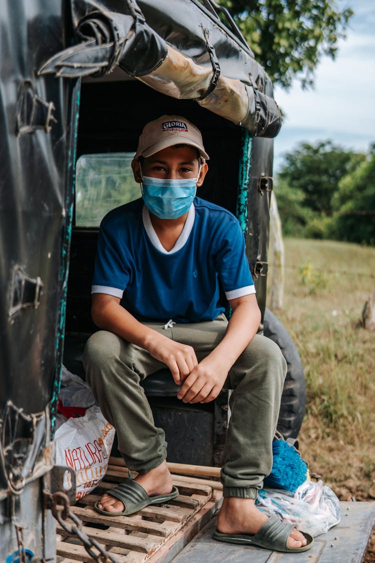 Man In White And Blue Shirt Wearing Facemask Sitting Inside A Car 