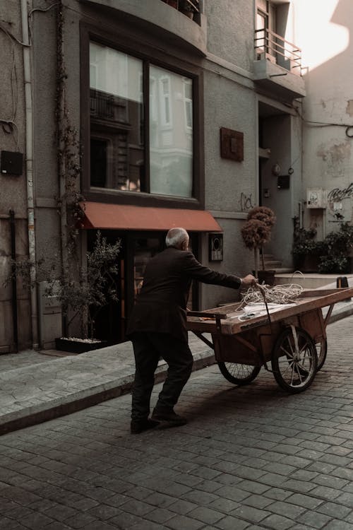 Senior Man Pushing a Cart on a Downtown Street