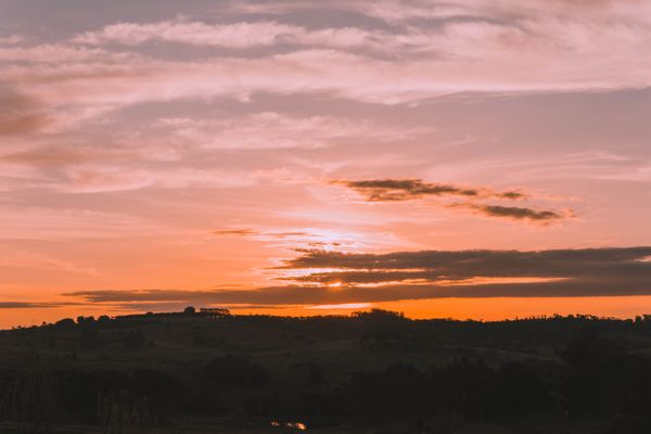 Pôr do sol de tirar o fôlego com cores vibrantes sobre a paisagem serena do campo de São Paulo.