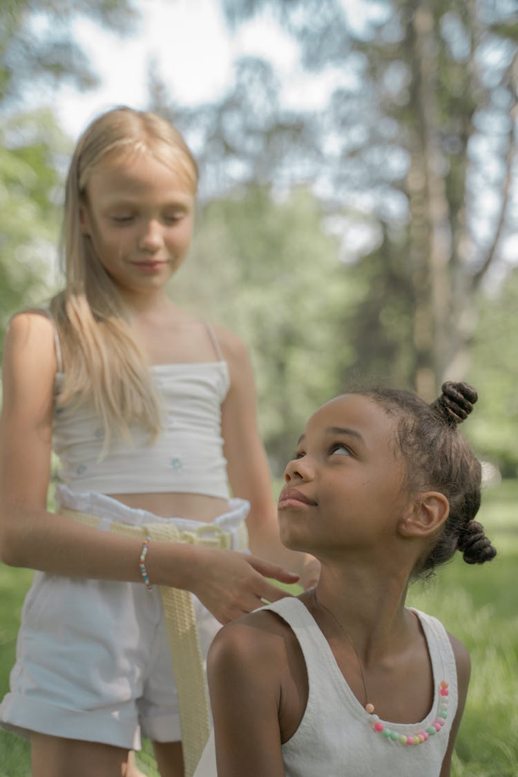 Girl Doing Her Friend Hair In Park